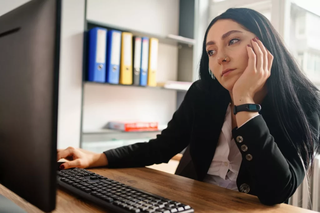 disengaged businesswoman at desk shows why knowledge management fails