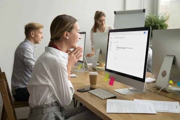 businesswoman smiling at computer is participating in channel incentive program