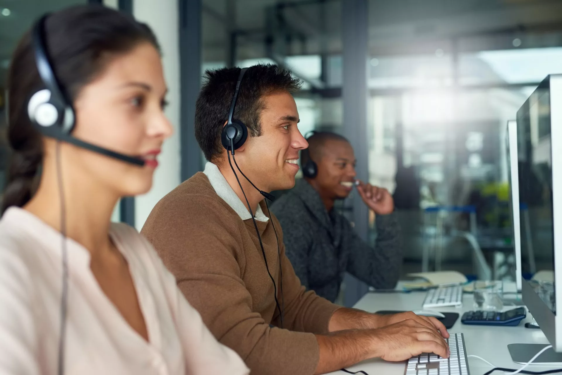 Call center employees at computers demonstrate employee engagement in customer service