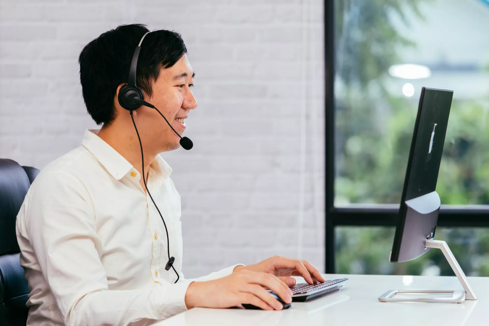 man on headset in office uses new contact center technologies