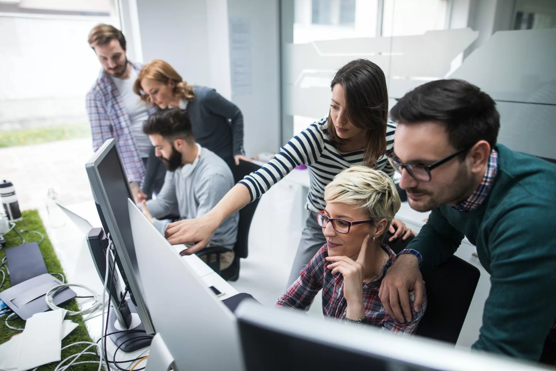 coworkers gathering around desk to share tacit knowledge