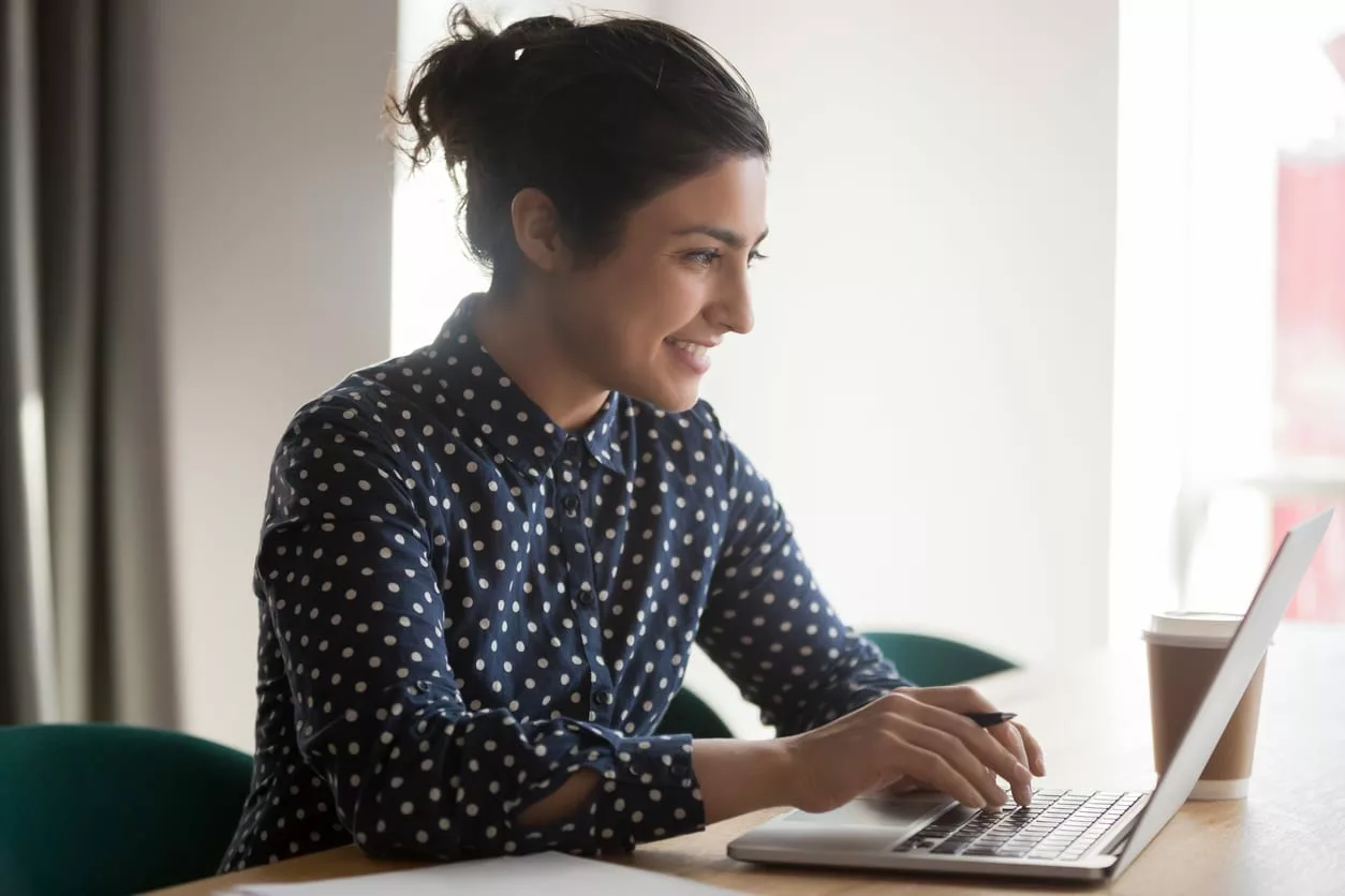 young office worker smiles while using Bloomfire's Curation Engine on laptop|||young office worker smiles while using Bloomfire's Curation Engine on laptop||