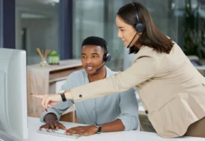 contact center leader points at monitor to empower customer service agents to find information