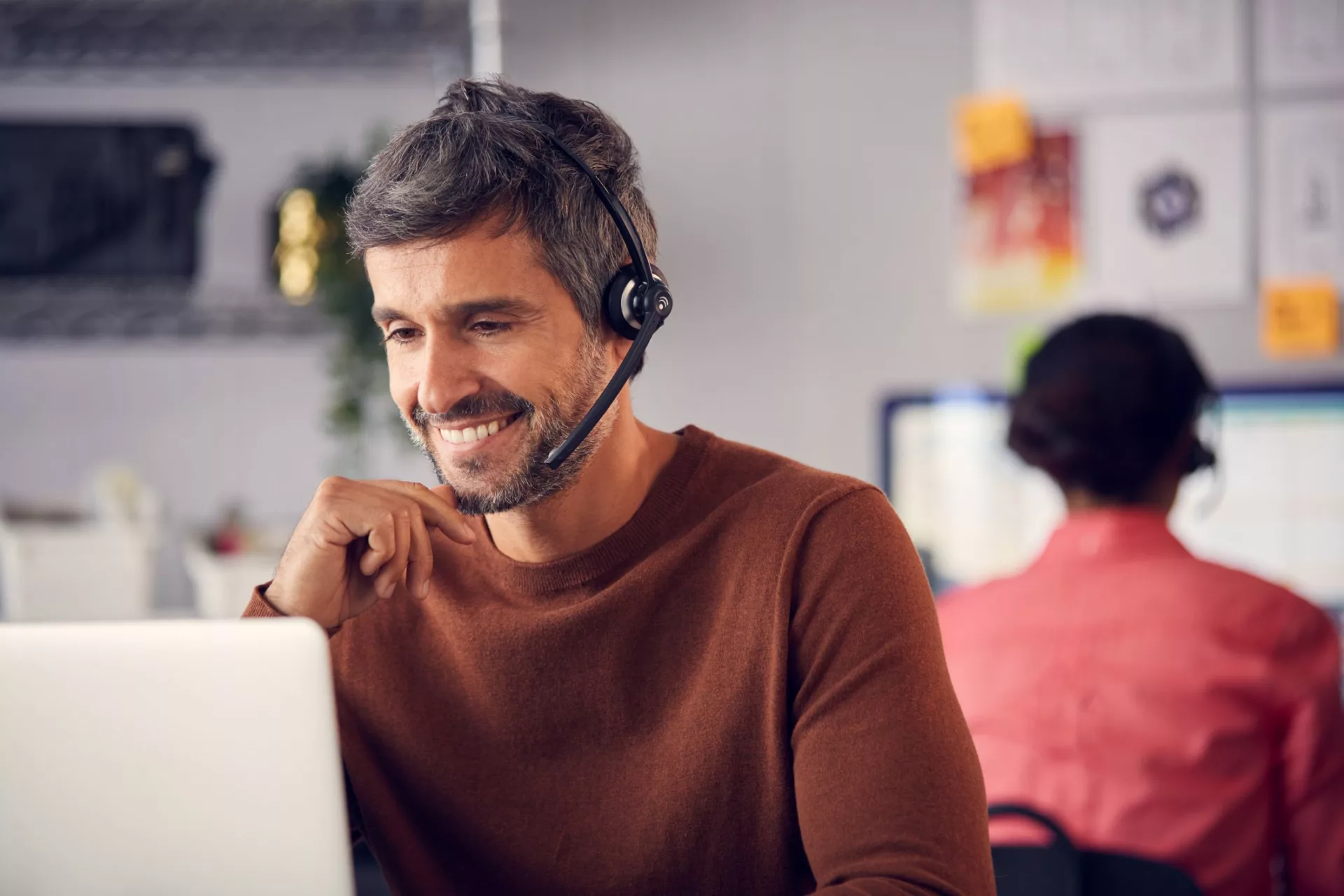 customer service team member reviewing customer knowledge management platform on laptop