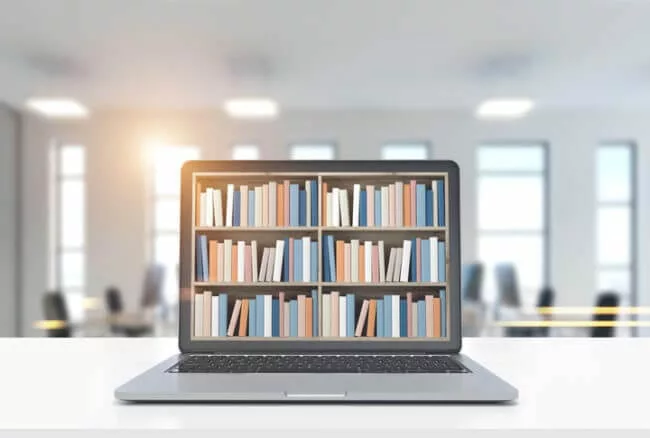 laptop with bookshelves shows knowledge base vs. knowledge sharing platform concept