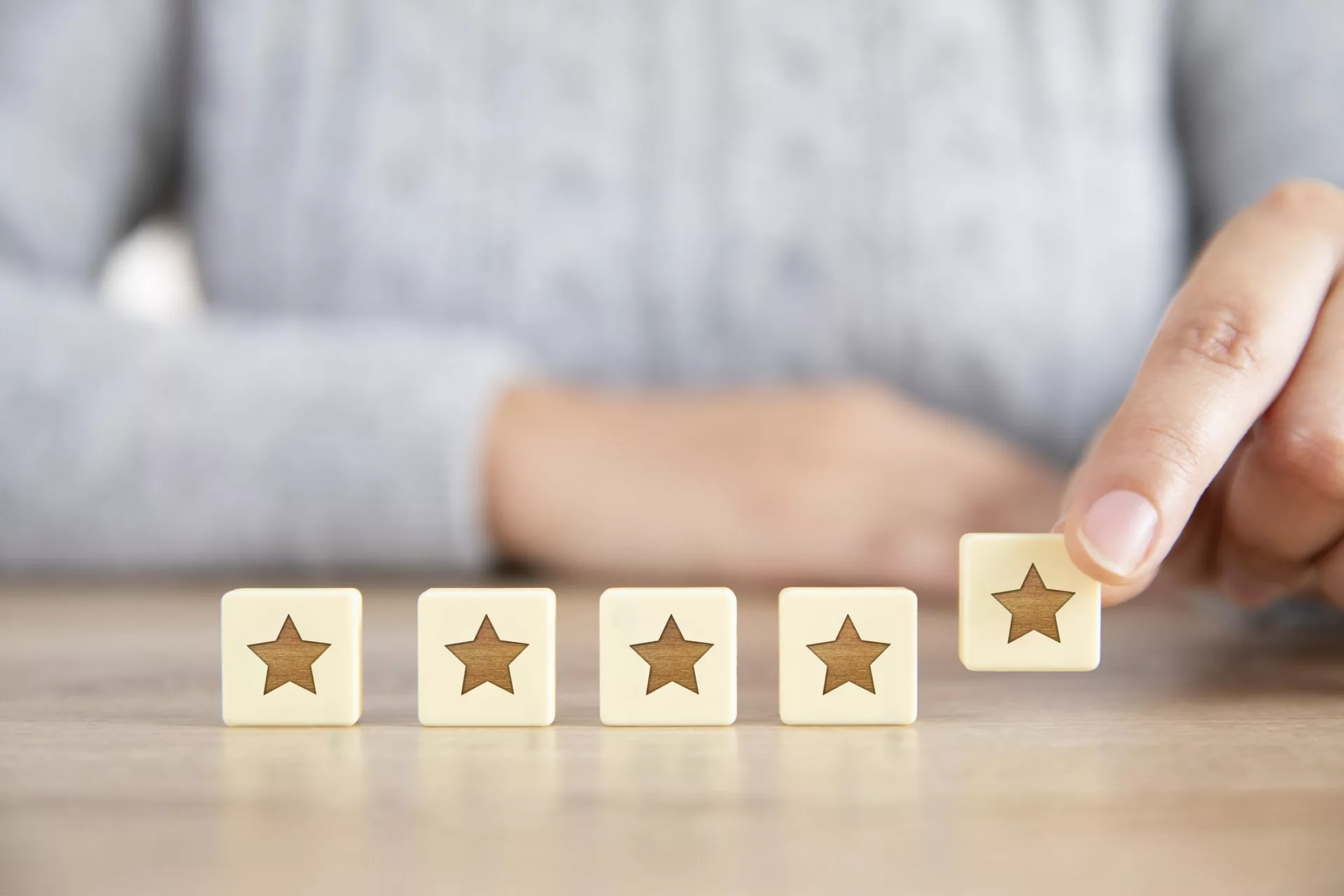 woman arranging five star blocks demonstrates customer satisfaction