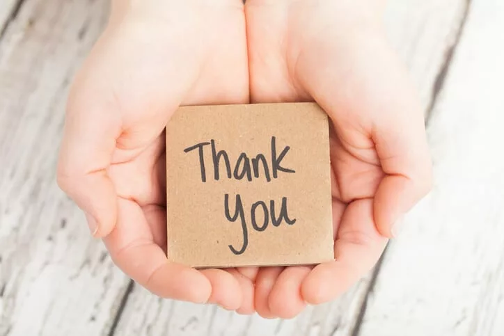 hands holding note to say thank you to your employees