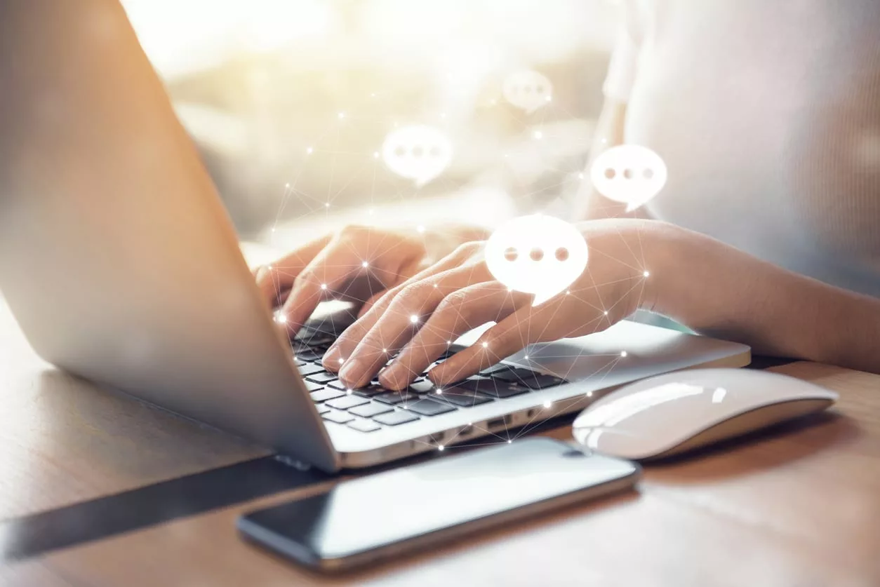 woman types on laptop with chat icons suggesting the best Slack apps