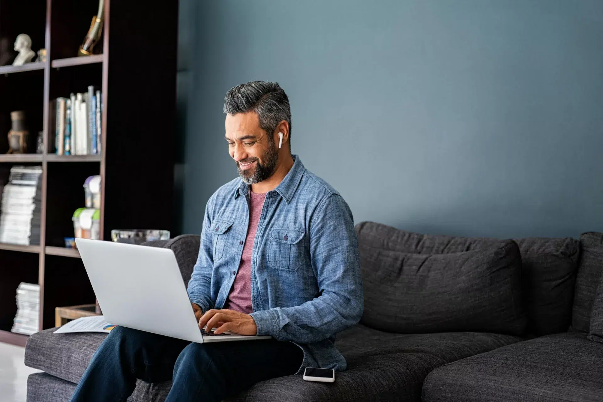 man wearing headphones and focusing on laptop demonstrates good workplace productivity