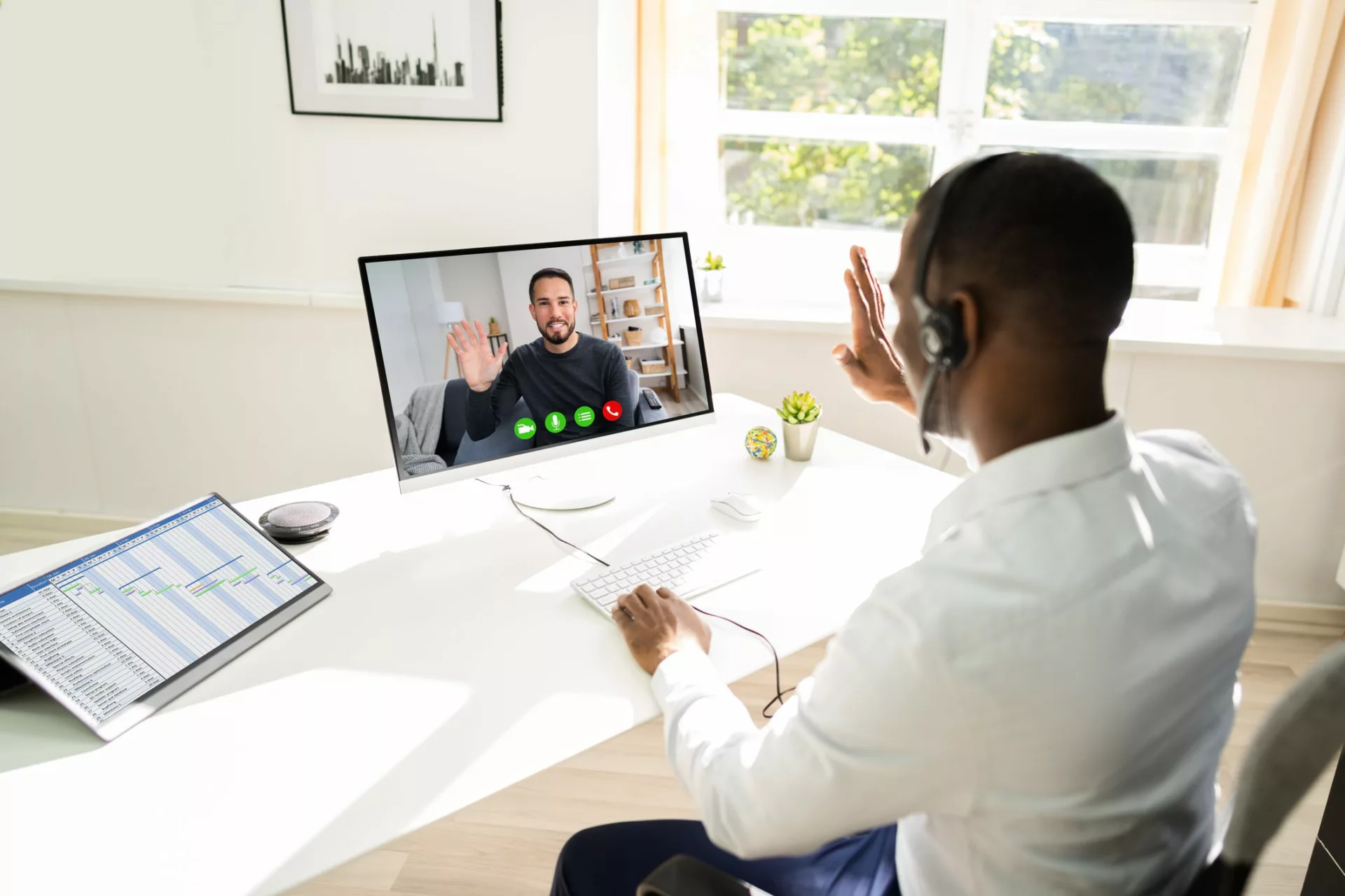 man on video calling waving goodbye to departing coworker and preparing for cost of losing an employee