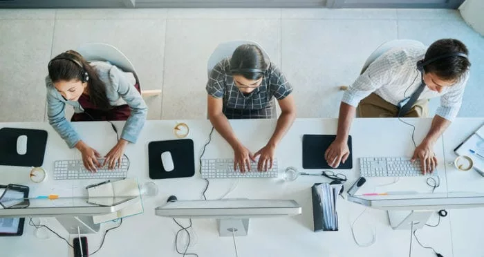 overhead view of sales team using searchable Q&A tool on their desktops