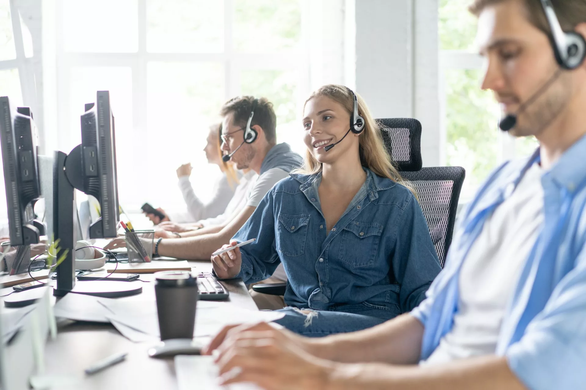 contact center agents in open office using the best knowledge management systems for customer service