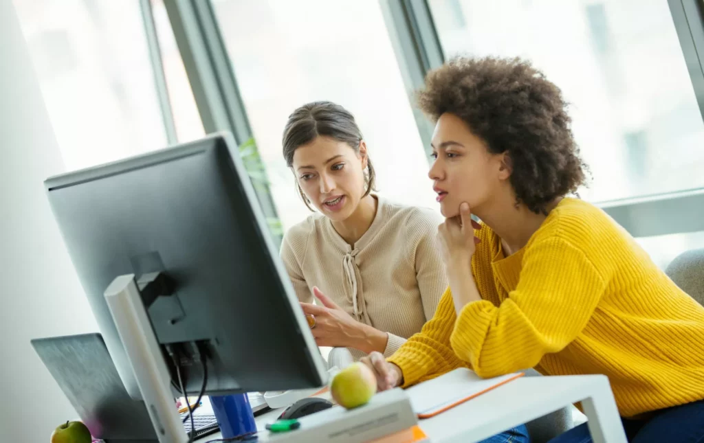 two women working together at desk on first-party data strategy