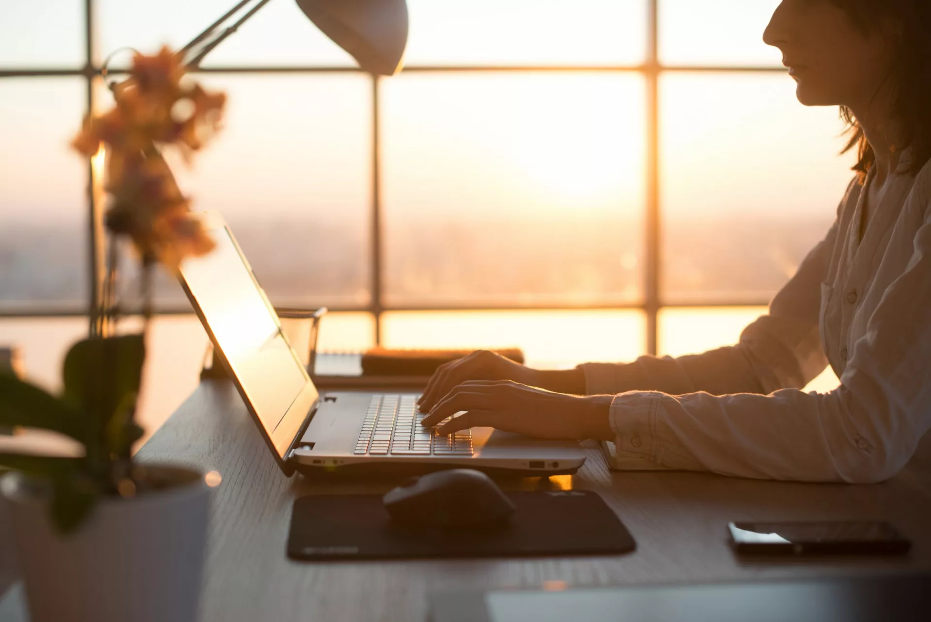 woman typing on laptop to increase content in knowledge management platform