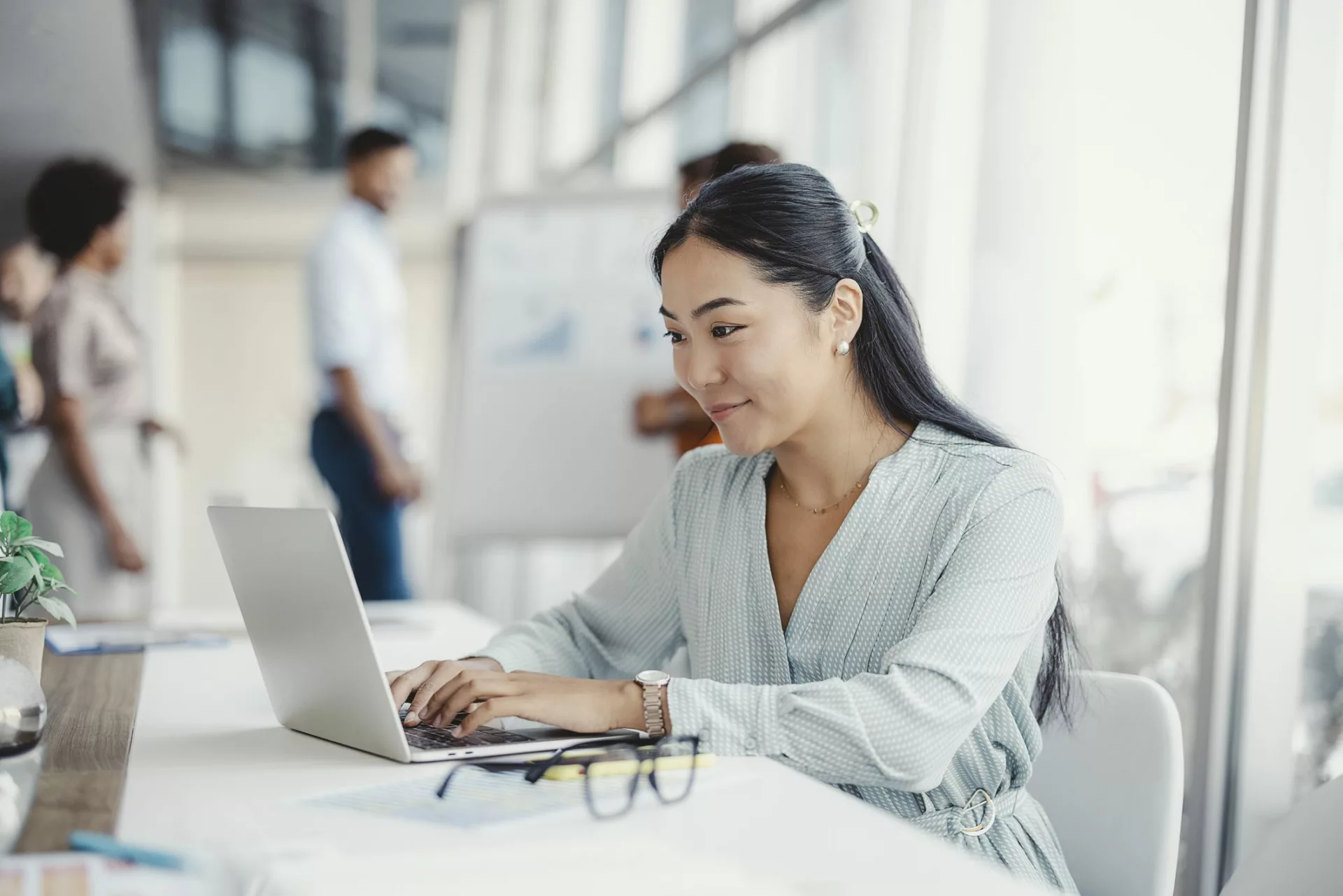 woman in office takes notes on laptop to help with knowledge retention