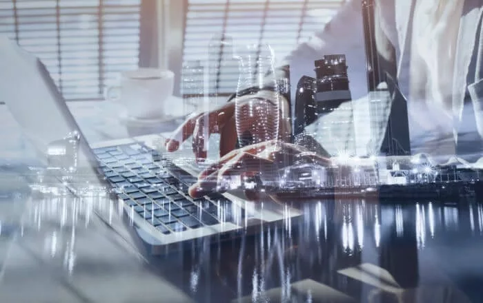 Businessperson typing on laptop representing knowledge management in financial services