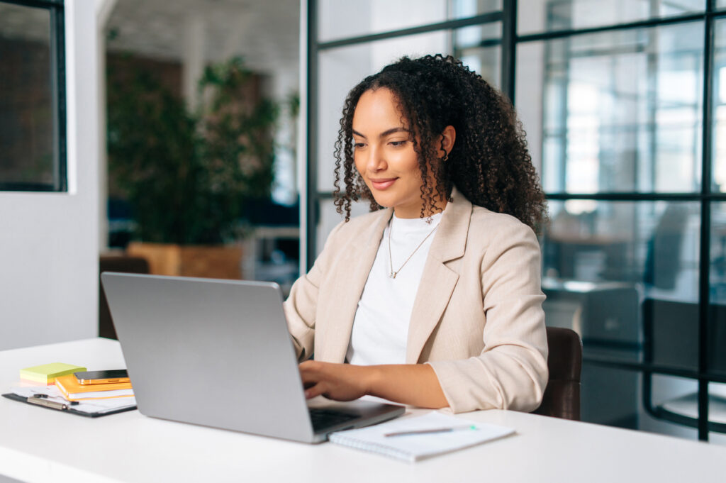 A woman in front of a computer, using Bloomfire's customer insights platform