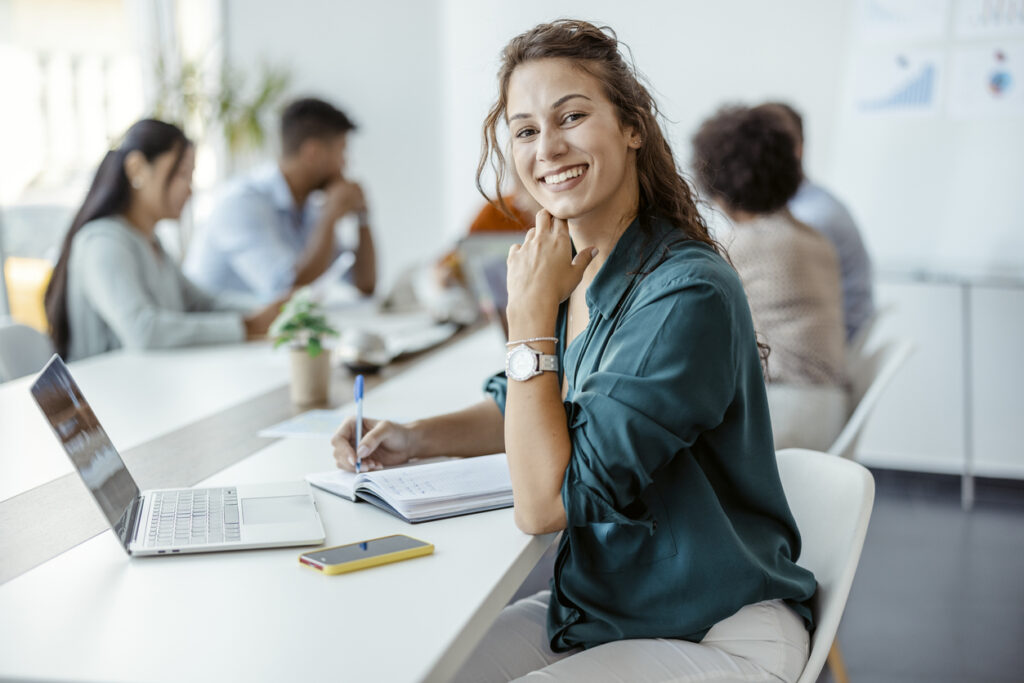 A woman smiling while using a company knowledge base