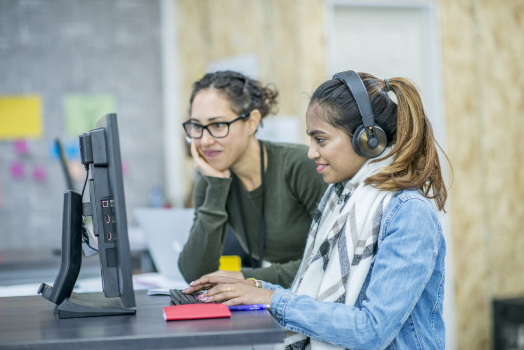 An employee teaching another employee how to organize a knowledge base