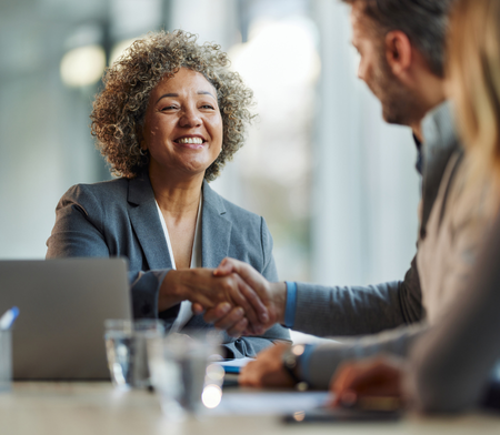 Two people in business casual dress shaking hands
