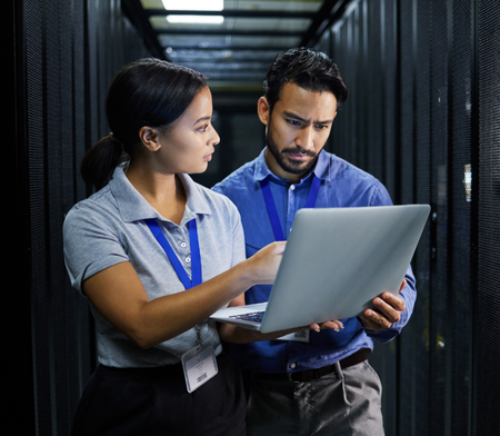 Two IT colleagues looking at a laptop