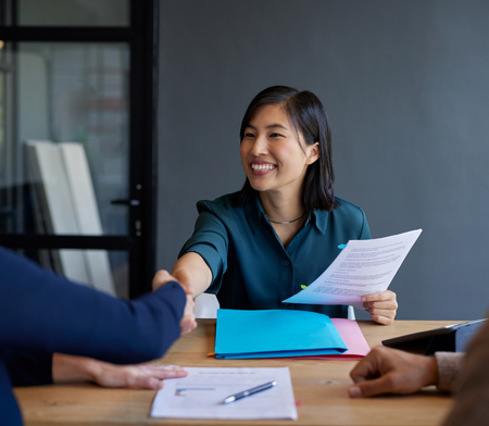 Female HR executive shaking hands with interview candidate
