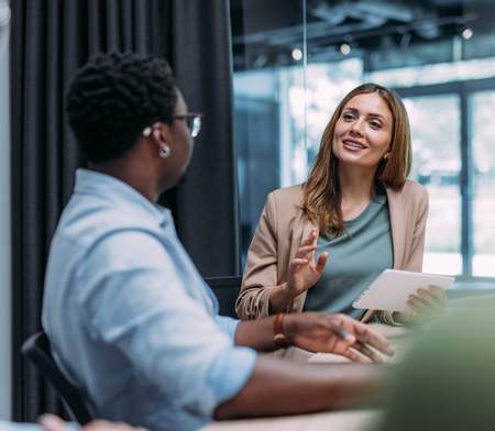Two female Human Resources colleagues talking at a table
