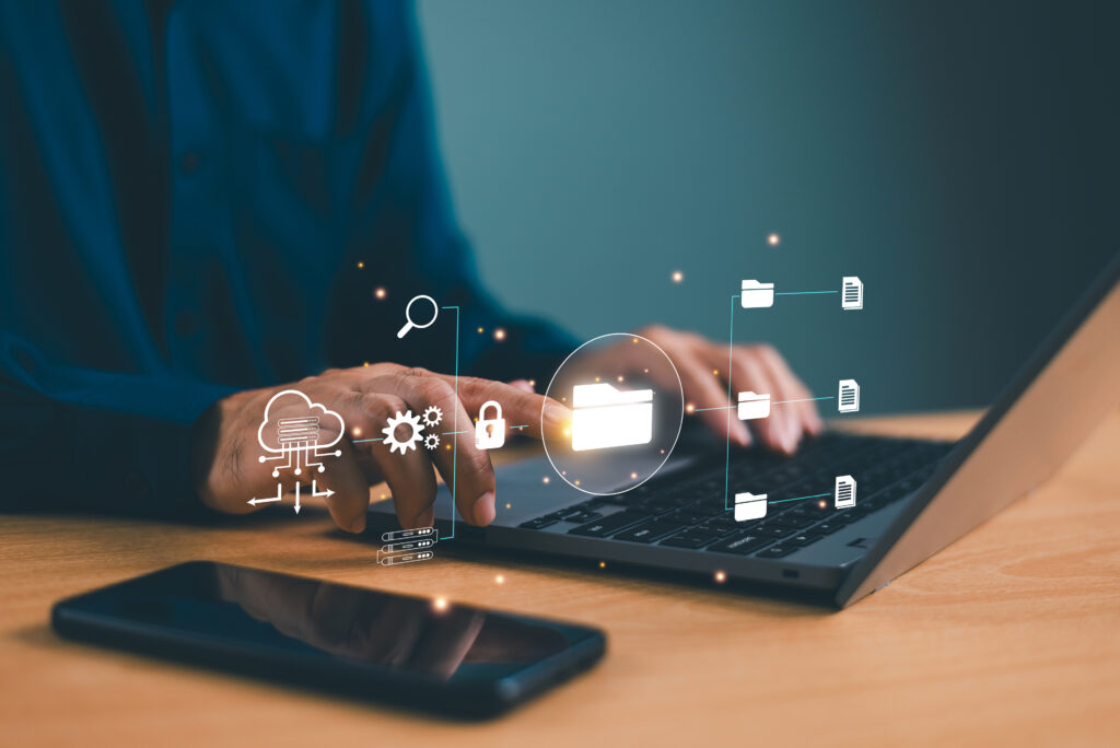 Person typing on a laptop with overlaid icons representing knowledge connectors syncing files, cloud data, and security across business systems